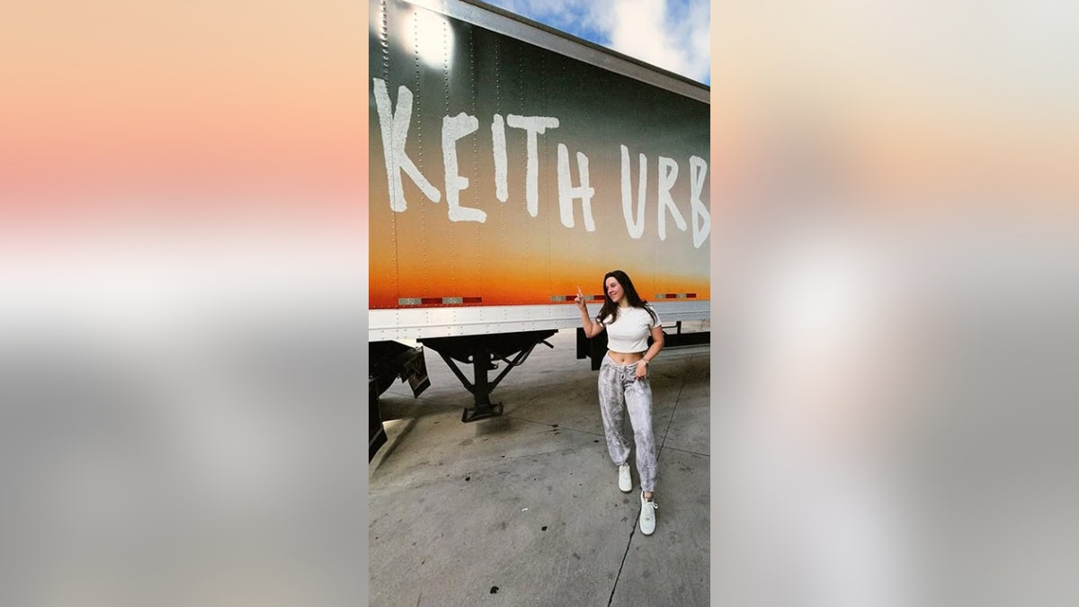Maggie Baugh standing in front of a keith urban labeled truck