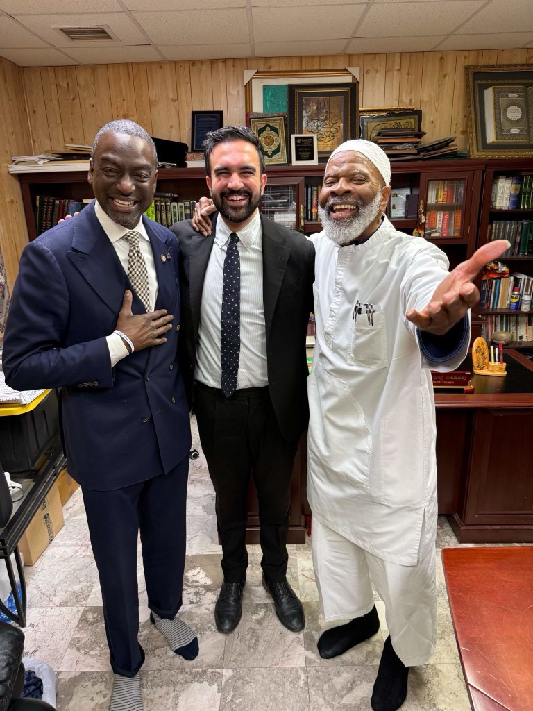 Three men, Mamdani, Imam Siraj Wahhaj, and another man, stand smiling for a photo.