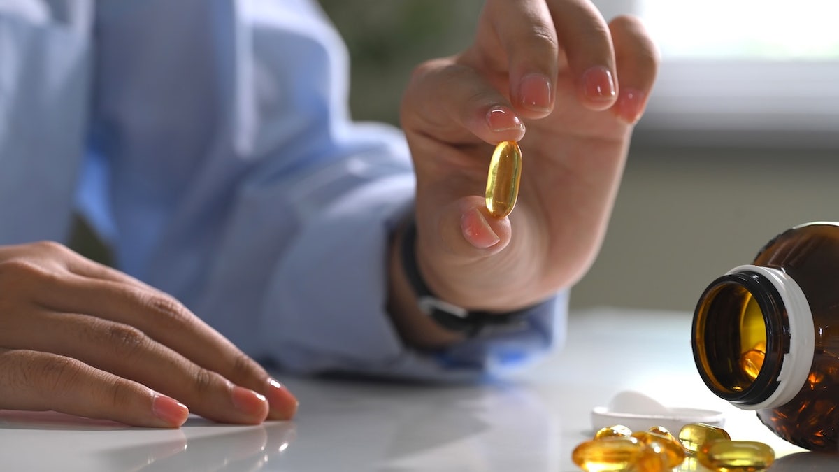 Man holding Vitamin D pill