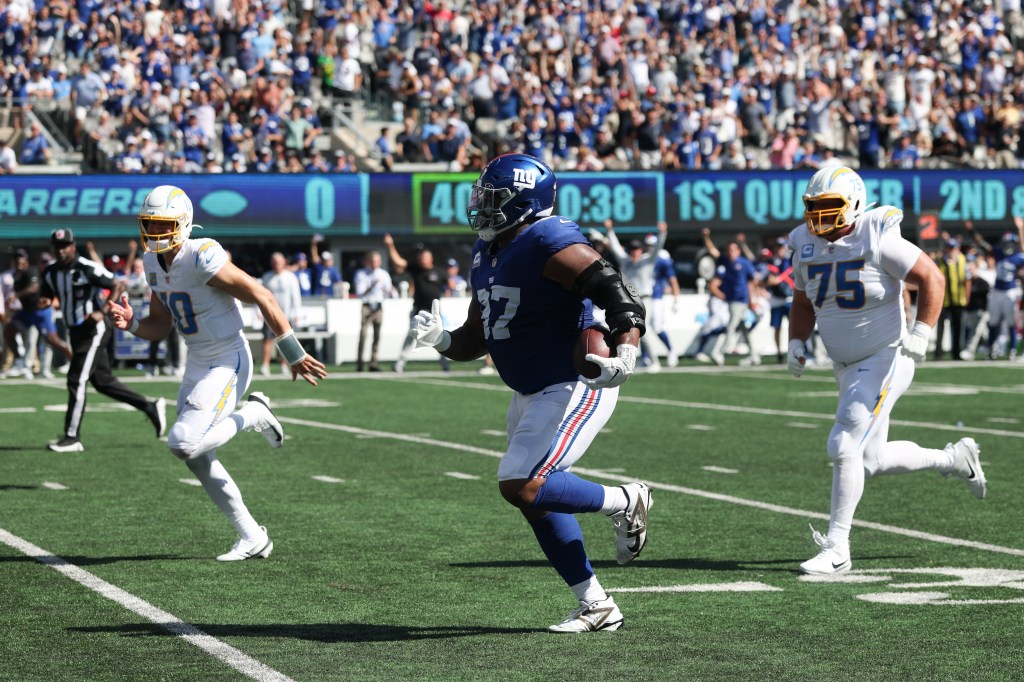 New York Giants defensive tackle Dexter Lawrence II (97) returns an interception as Los Angeles Chargers quarterback Justin Herbert (10) and Los Angeles Chargers center Bradley Bozeman (75) defend during the first quarter at MetLife Stadium.