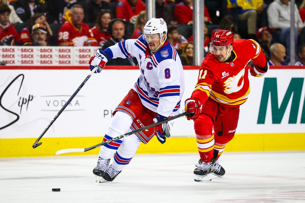 Rangers center J.T. Miller (8) and Calgary Flames center Mikael Backlund (11) battles for the puck during the third period at Scotiabank Saddledome.