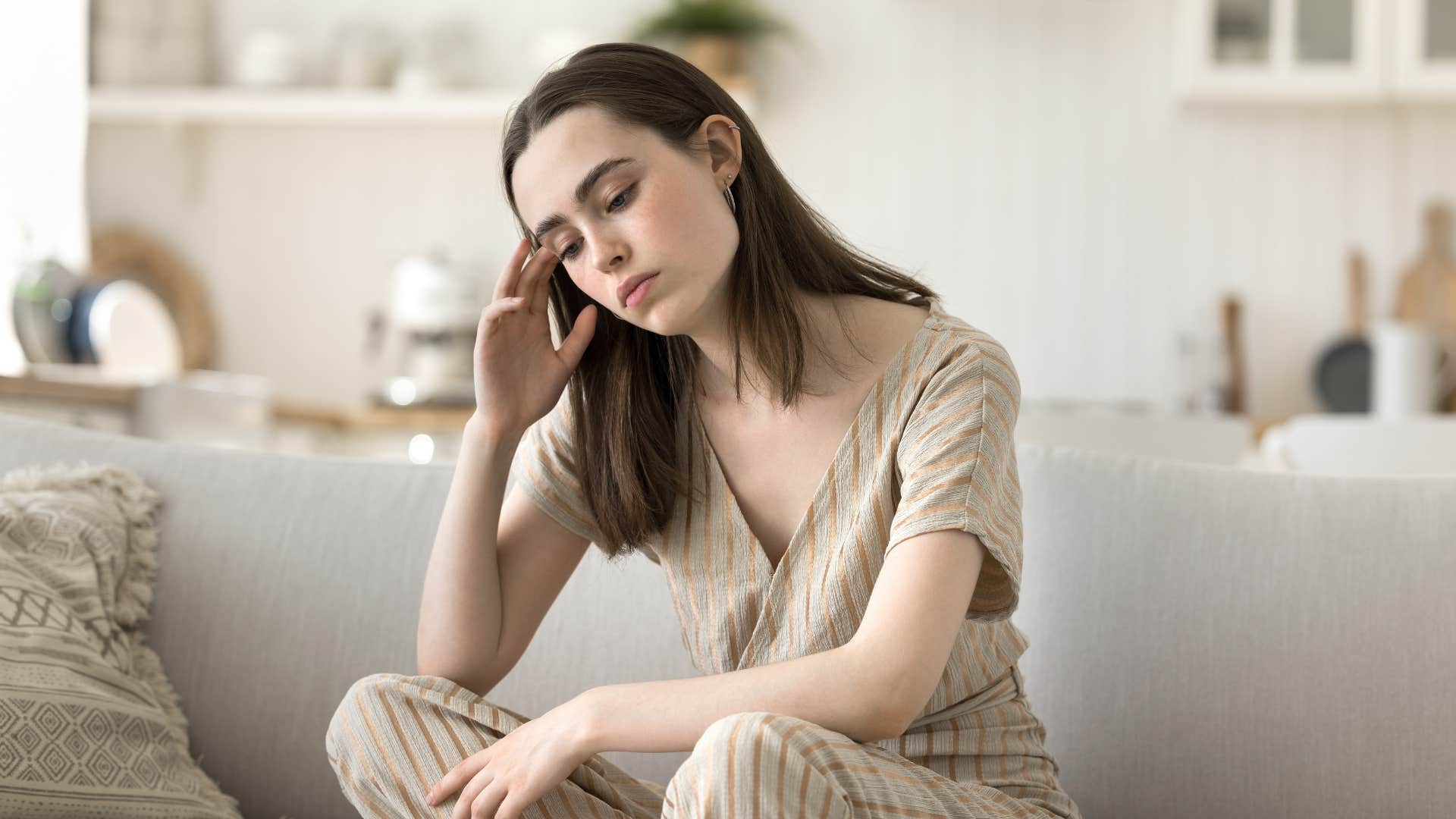 anxious woman sitting in her living room worrying