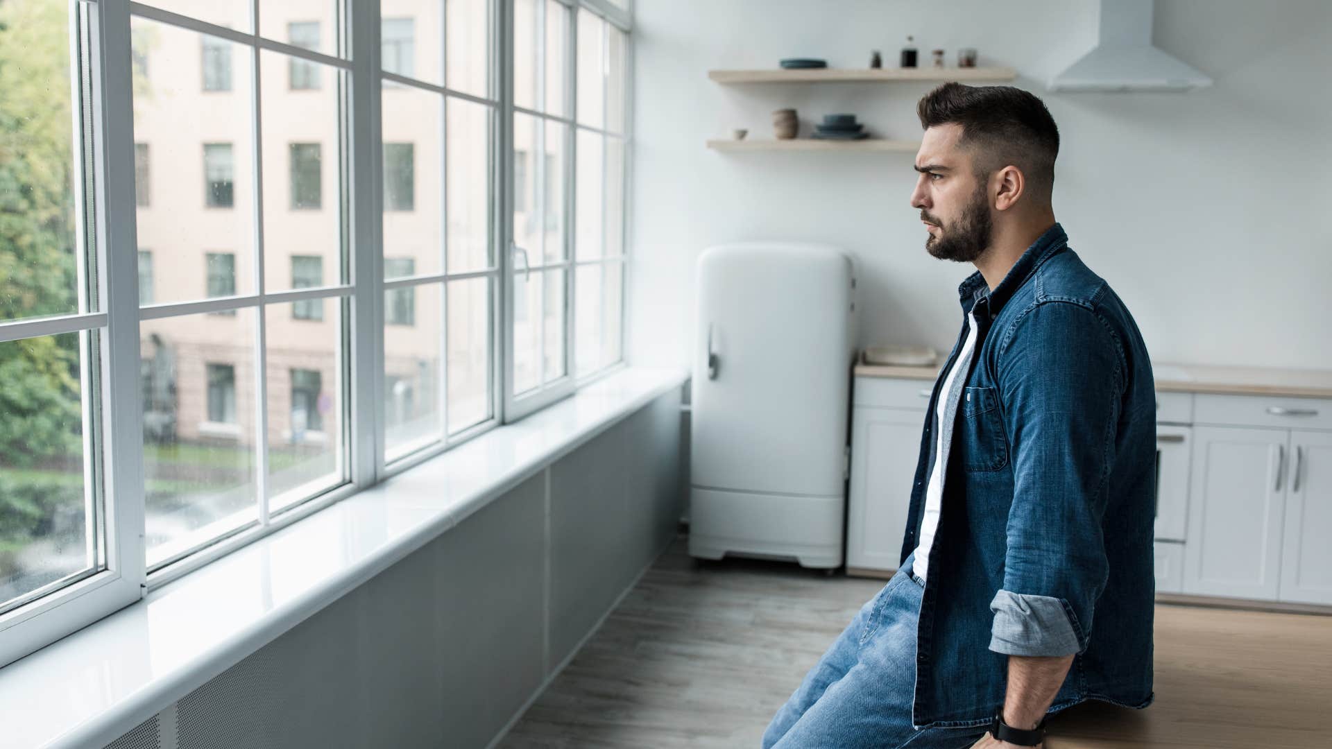 sad man sitting in empty kitchen