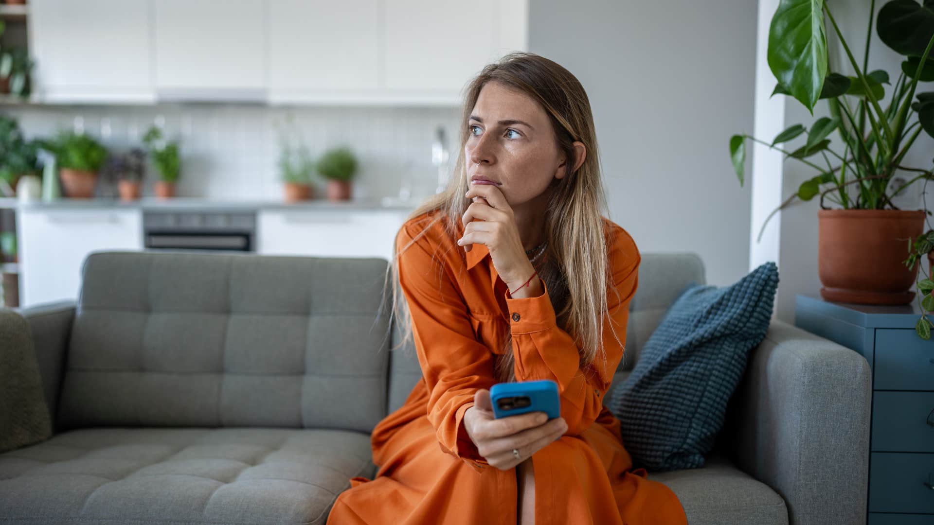 struggling woman sitting in silence in living room