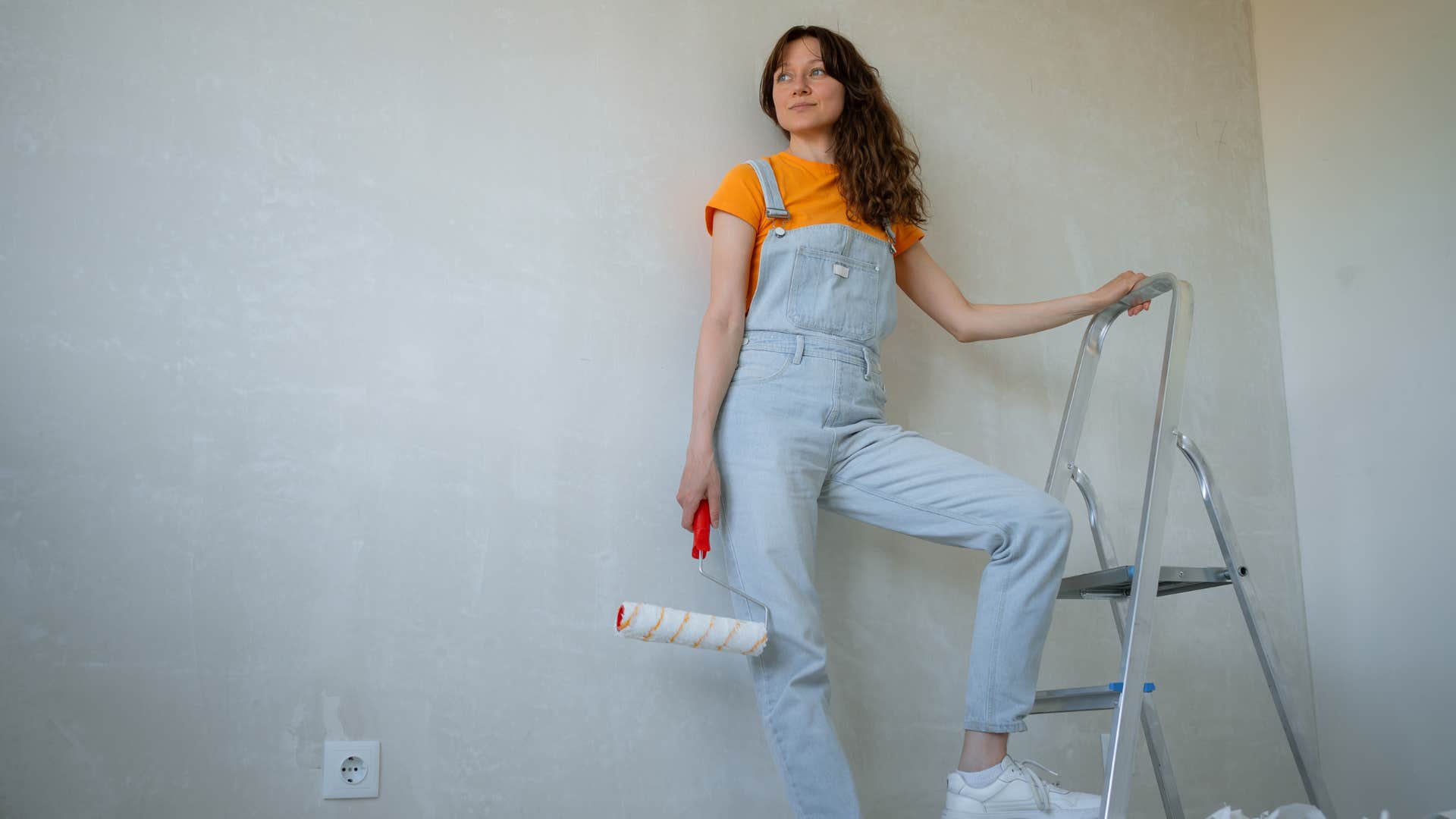 woman working on unfinished project painting her home