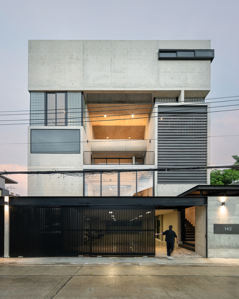 green courtyard anchors hybrid home and office within concrete structure in bangkok
