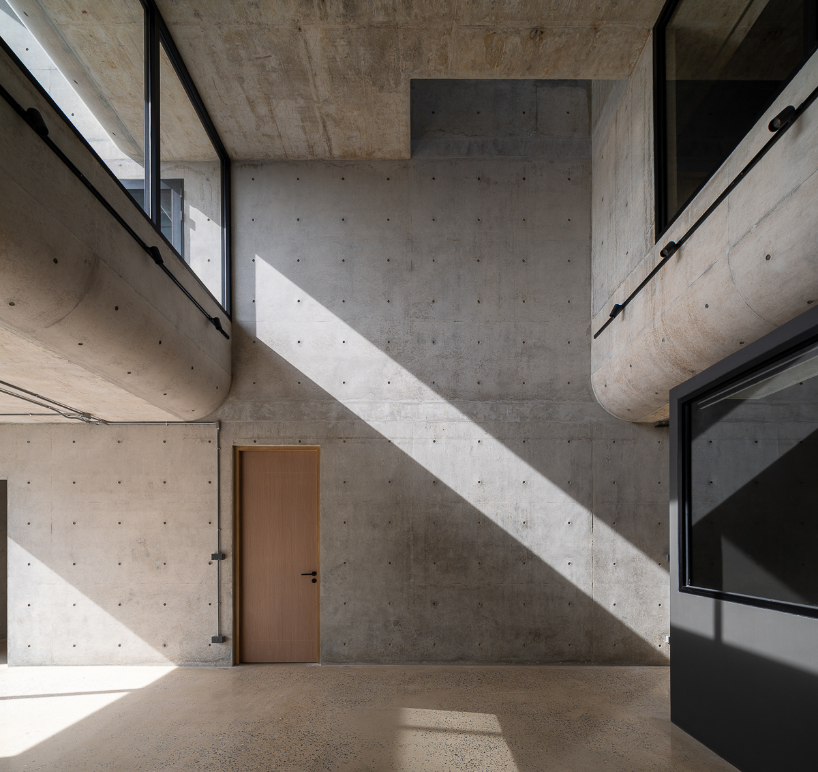 green courtyard anchors hybrid home and office within concrete structure in bangkok