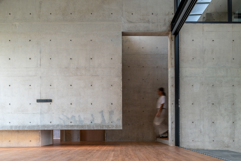 green courtyard anchors hybrid home and office within concrete structure in bangkok