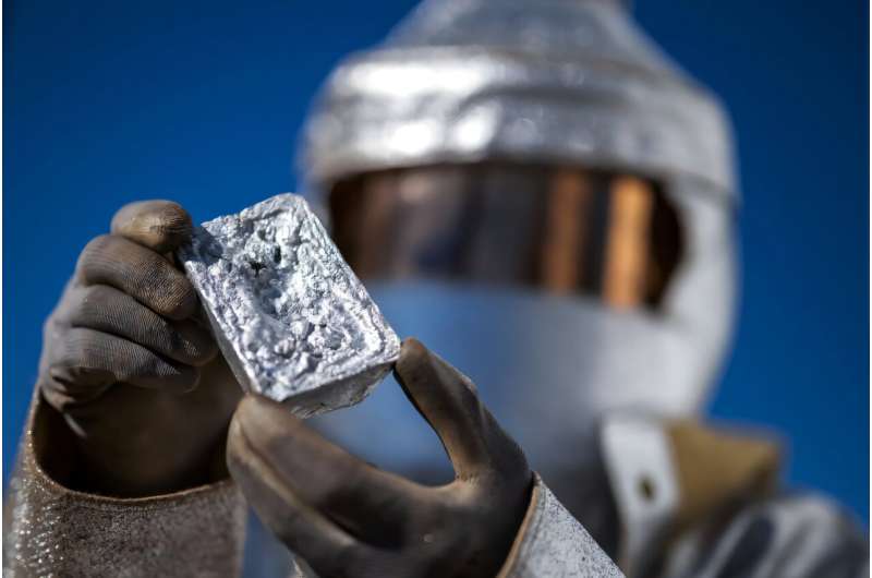 Panatere metallurgical engineer Jean-Francois Dionne, wearing a thermal protective suit, shows an aluminum ingot. Panatere metallurgical engineer Jean-Francois Dionne, wearing a thermal protective suit, shows an aluminium ingot