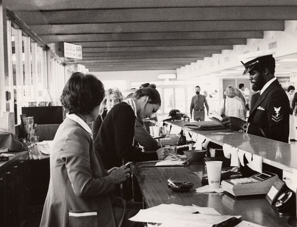 Employees work a car rental counter inside Sky Harbor Airport.