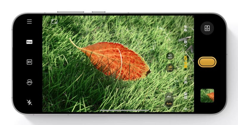 A smartphone screen shows a close-up photo of a red-orange leaf lying on green grass, with camera controls and settings visible on the display.