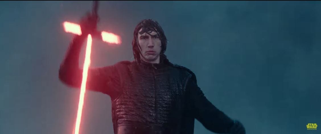 Kylo Ren in black robes wields a red cross-shaped lightsaber in the rain