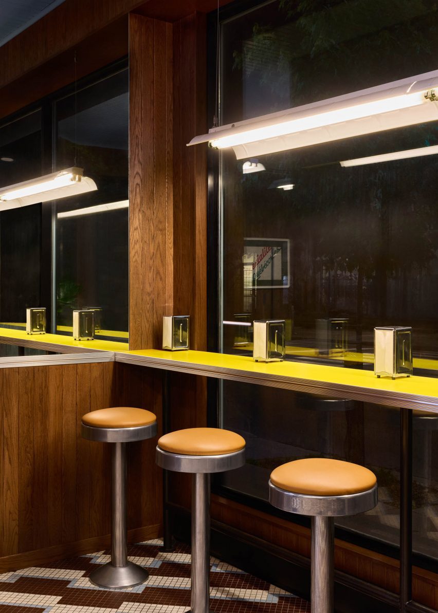 Retro-style stools positioned along a counter against a street-facing window