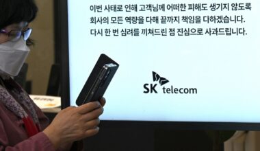 A woman uses her mobile phone while waiting to replace her USIM ship in front of an SK Telecom branch in Seoul on April 28, 2025.