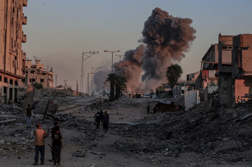Smoke from an Israeli airstrike rises above damaged buildings in Gaza City.