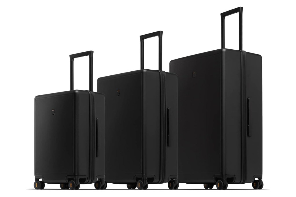 Three black suitcases in varying sizes from small to large with their handles extended, against a white background.