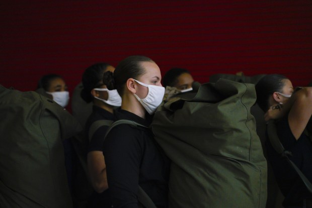 The first women recruits at Marine Corps Recruit Depot in San Diego on Feb. 9, 2021, carry their seabags awaiting their next orders during processing for their first day of boot camp. (Nelvin C. Cepeda / The San Diego Union-Tribune)