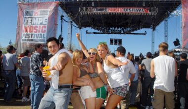 Four friends stand in front of a music festival stage.