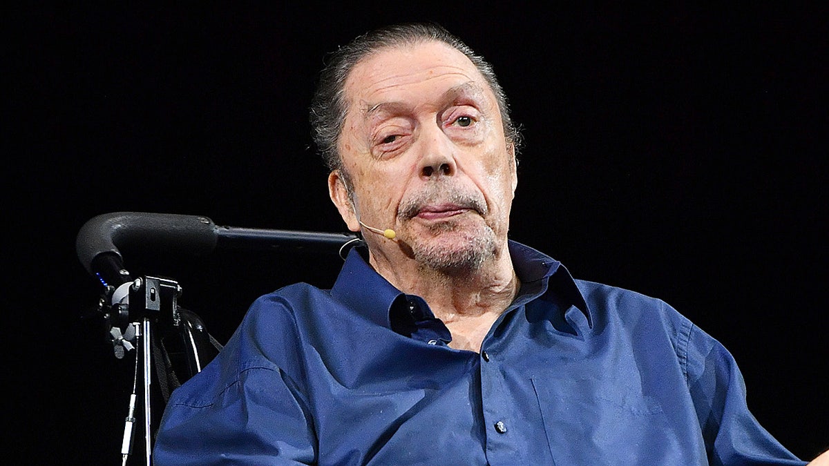 Tim Curry speaking to an audience, sitting in wheelchair