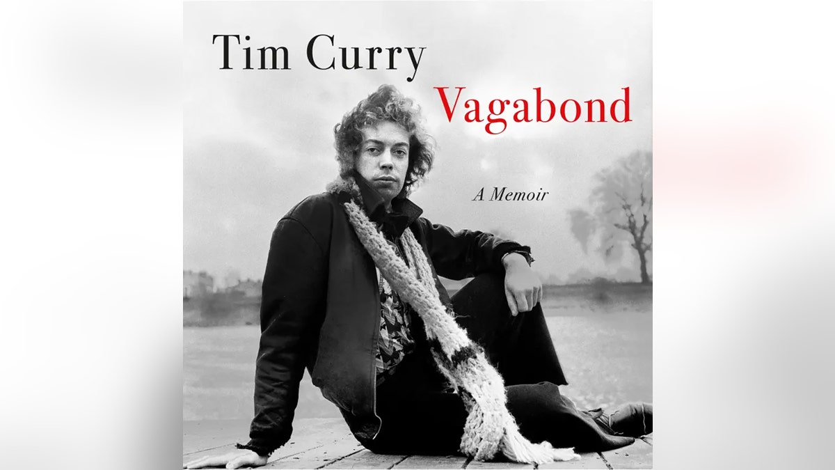 The cover of Tim Curry's new memoir "Vagabond." He is sititng outside looking at the camera with his legs crossed.