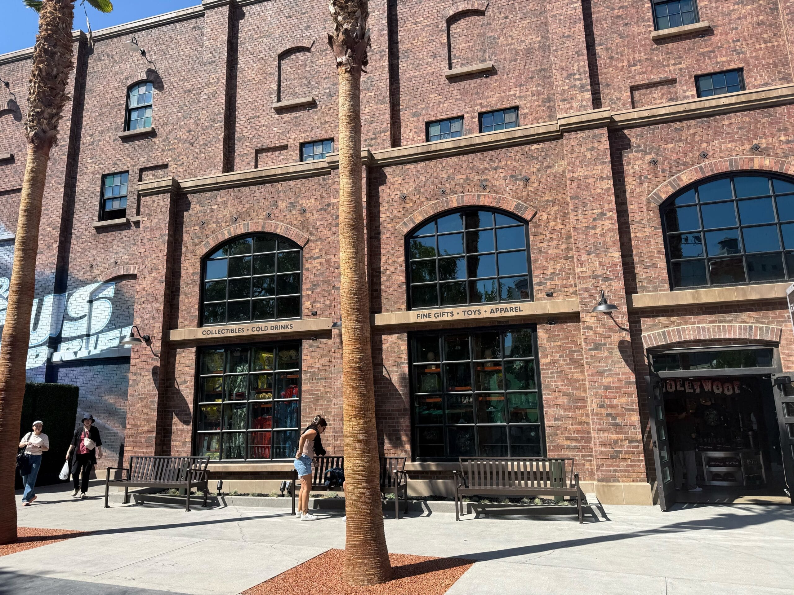 Brick building with large windows near Universal Studios, benches and palm trees—no Disney castle but energetic scene like Fast & Furious.