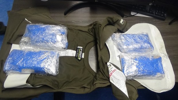 FILE - Authorities found vacuum-sealed bags, three with cigarettes, the fourth with marijuana, hidden inside a vest being worn by a correction officer at the Metropolitan Detention Center earlier this year. (United States District Court) 