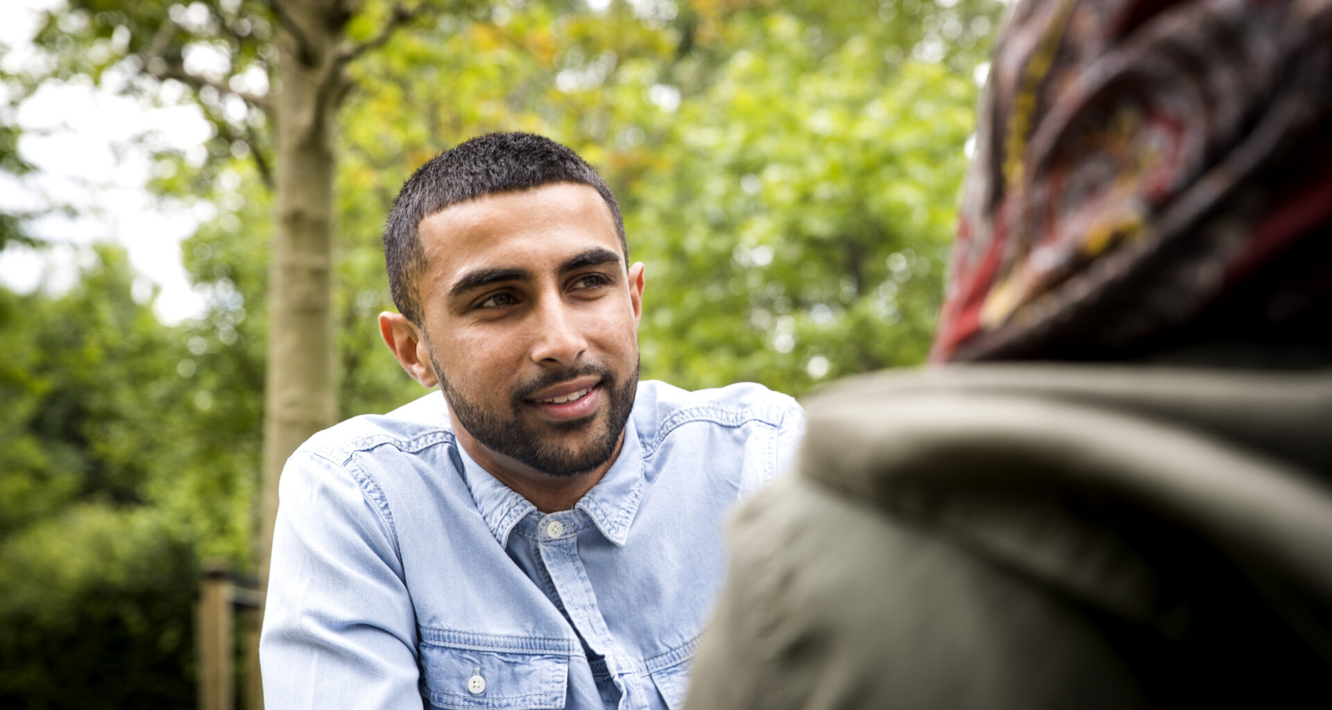 View over shoulder on man looking at friend
