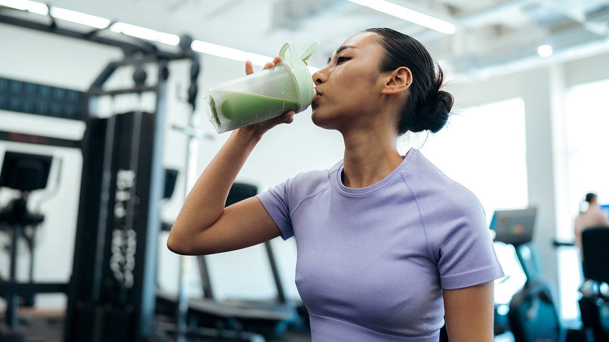 woman at the gym drinking protein shake