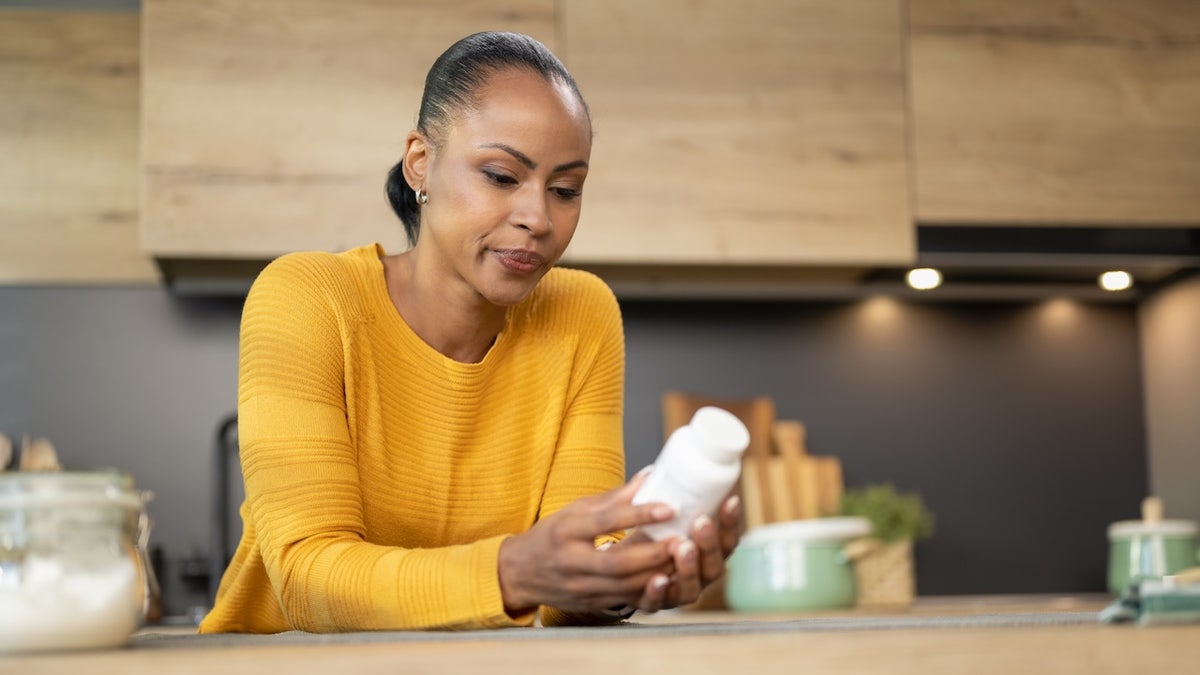 Woman looking at vitamin bottle