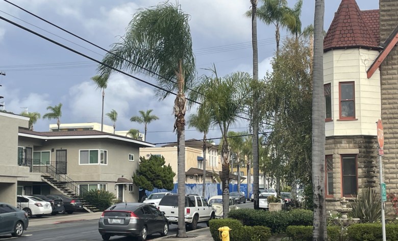 A view of a residential neighborhood drying out from a storm, with dark clouds still looming.