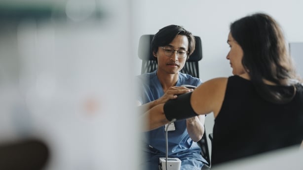 Woman getting her blood pressure checked by GP