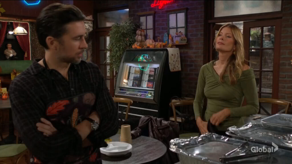 Phyllis takes off her apron as Cane looks on.