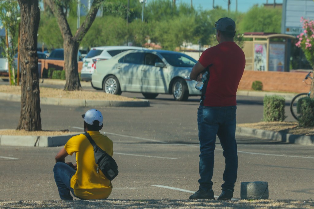 Two men look for work in a Home Depot parking lot on Oct. 28, 2025, in Phoenix. 