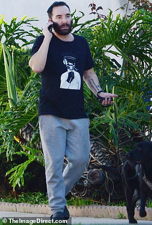 The star slipped into a pair of black shoes and held a conversation on the phone while enjoying the warm sunshine