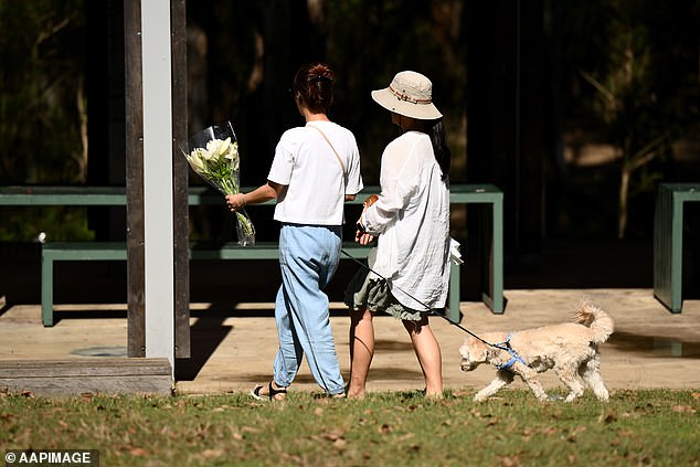 People are seen leaving flowers at the scene where the teenager was fatally stabbed
