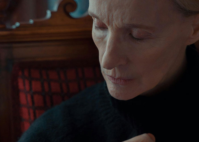 Elderly woman in deep thought, capturing the emotional challenges psychiatric institution workers face on the job.