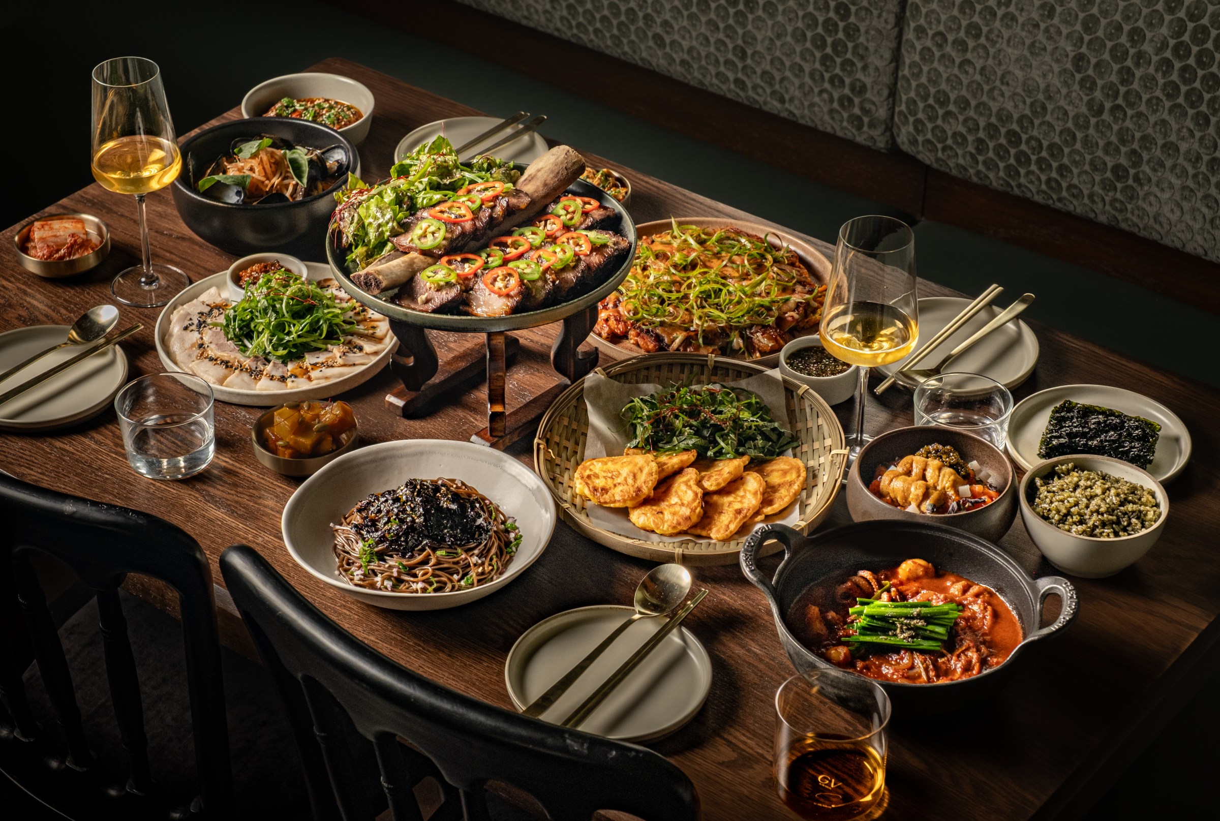 Spread of dishes at Hojokban on a table with glasses of wine