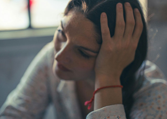 Young woman in a psychiatric institution looking thoughtful and distressed, reflecting on unforgettable moments on the job.