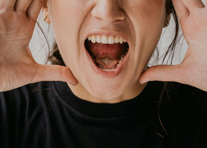 Close-up of a person in a black shirt expressing strong emotions, related to psychiatric institution workers' unforgettable moments.