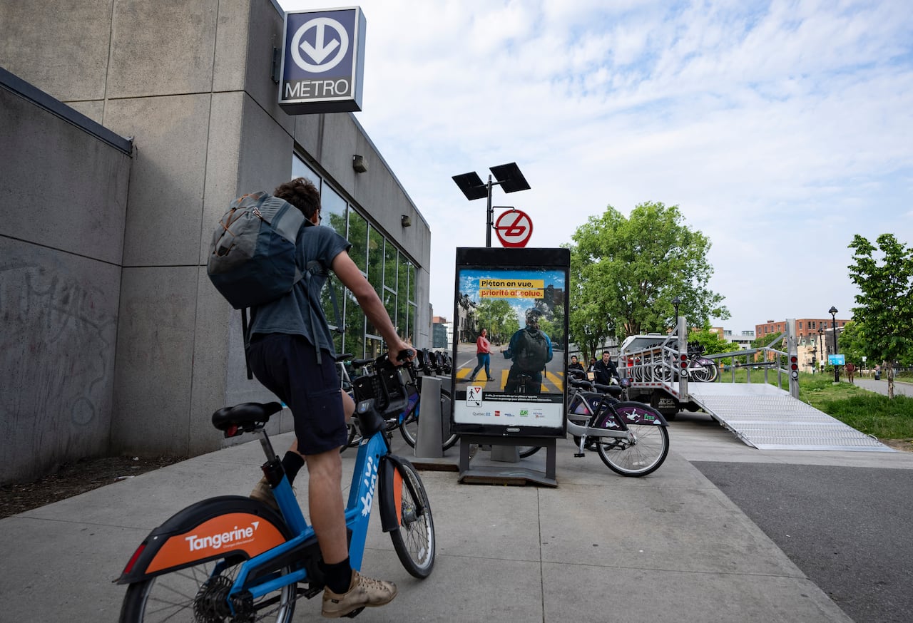 A Bixi bike rider pulls in to a Metro station 