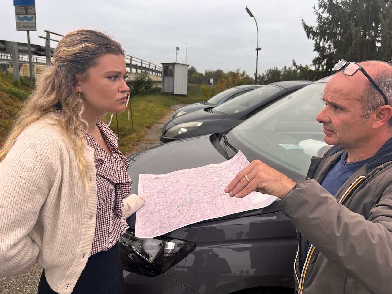A man shows a map to a woman that shows battles that a Canadian army regiment fought in Italy during the Second World War.