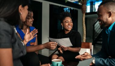 A group of young professionals meeting up and chatting, smiling.