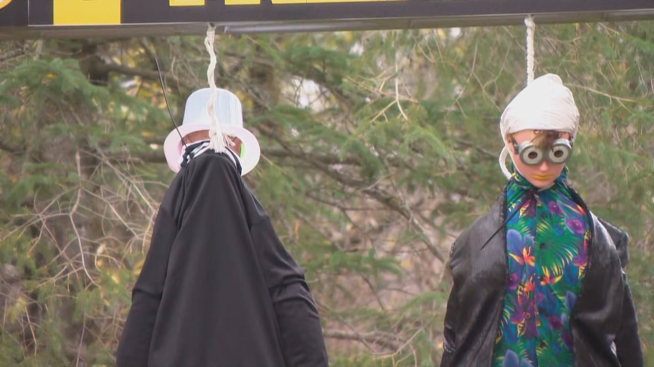 Two lifesize dolls hang from a gallows 
