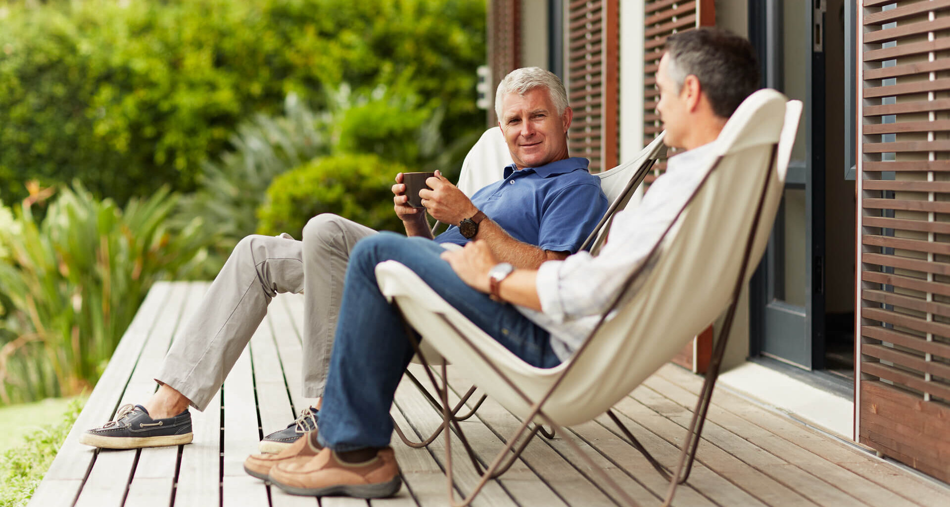 Full length of mature male friends spending leisure time at yard.