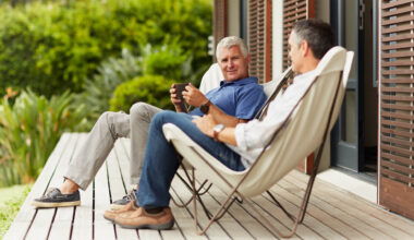 Full length of mature male friends spending leisure time at yard.