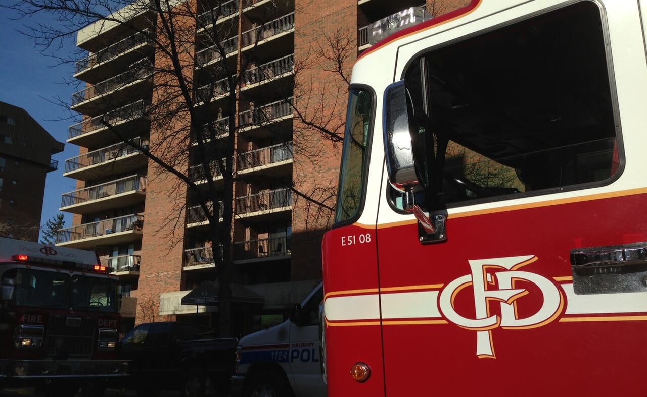 Two firetrucks parked in front of an apartment building