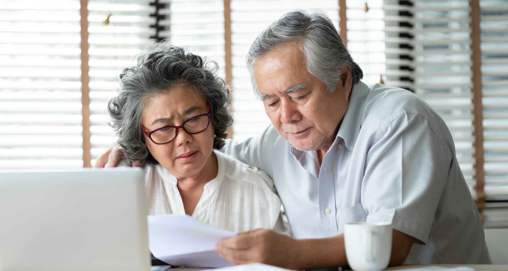 A senior couple reviews their finances and plans their retirement.