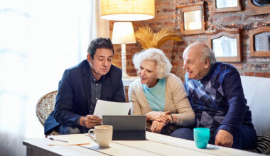 Financial advisor explaining senior couple at home.