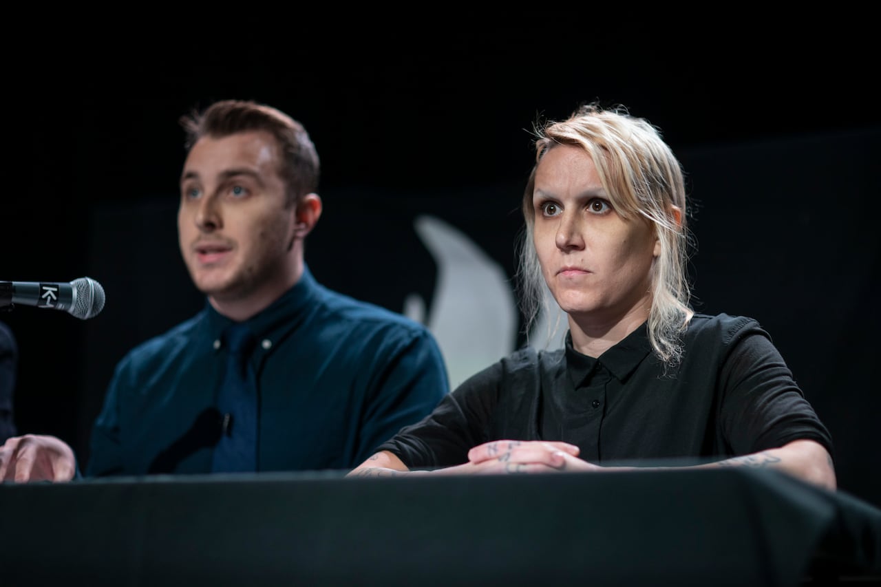 A woman with short blonde hair sits beside a man with short brown hair.