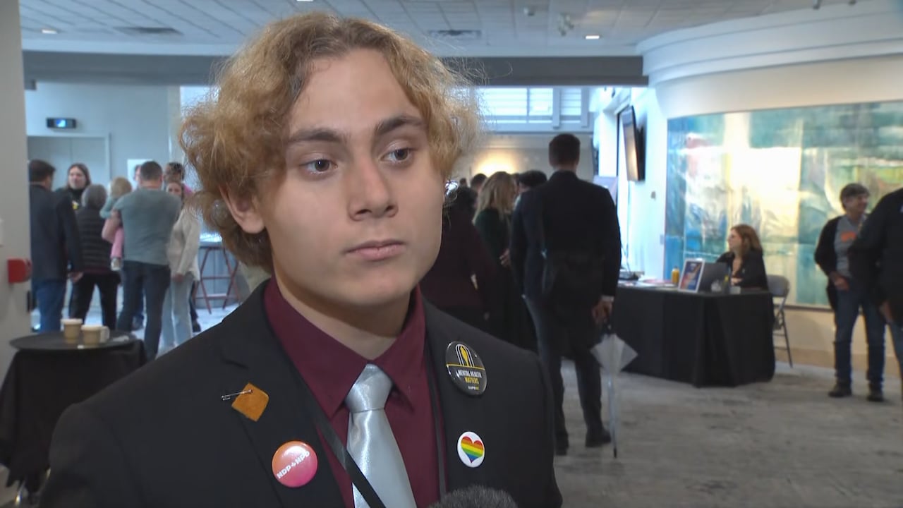 A man in a suit stands in a room